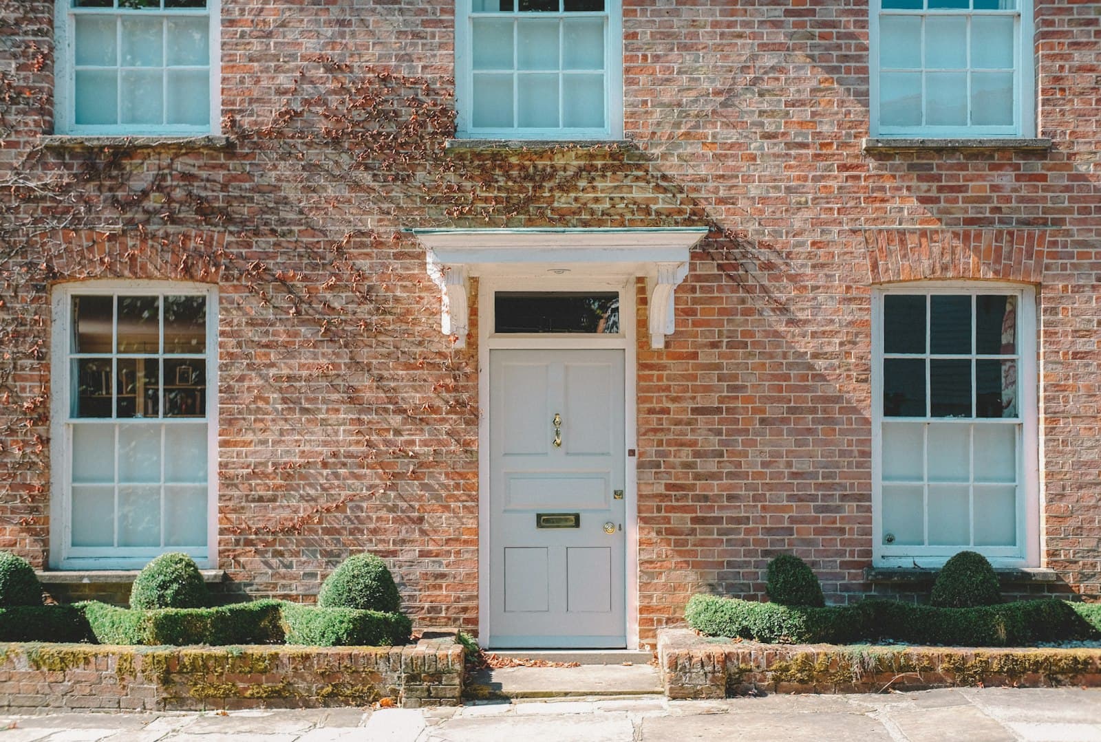 White wooden entry door on a brick home