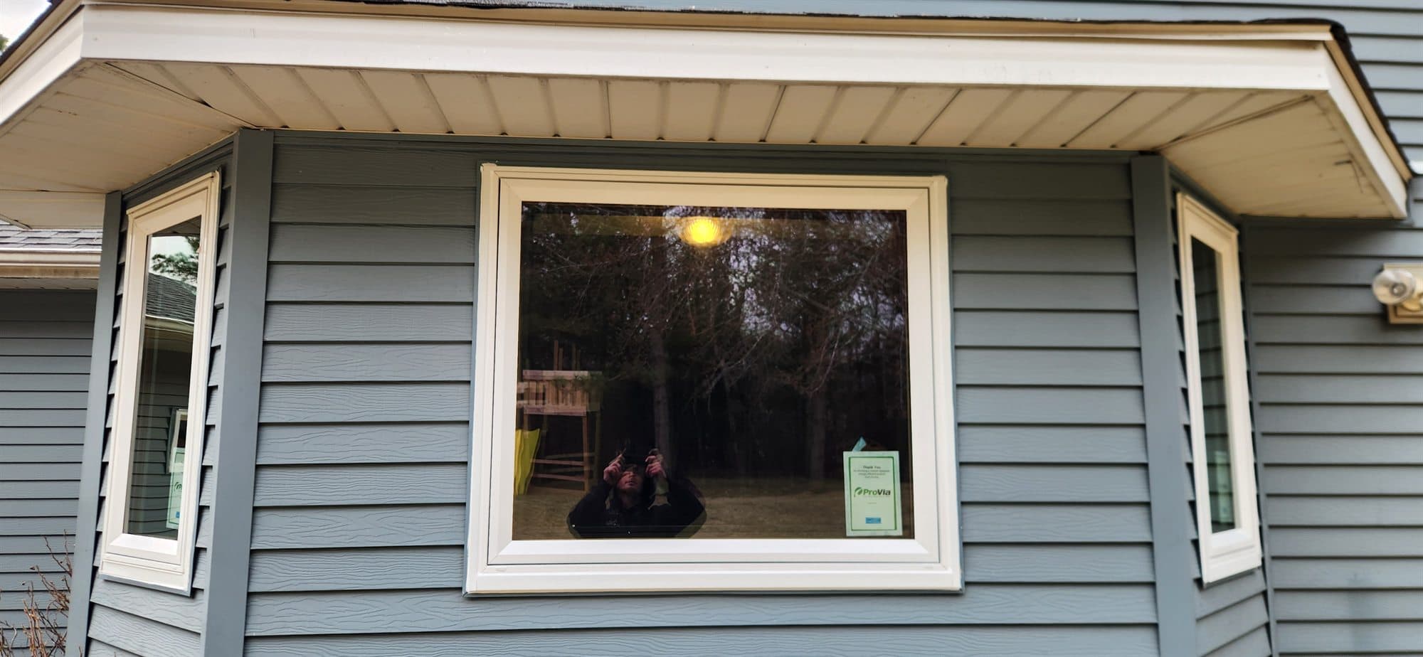 New ProVia picture window with energy rating label installed on a blue house