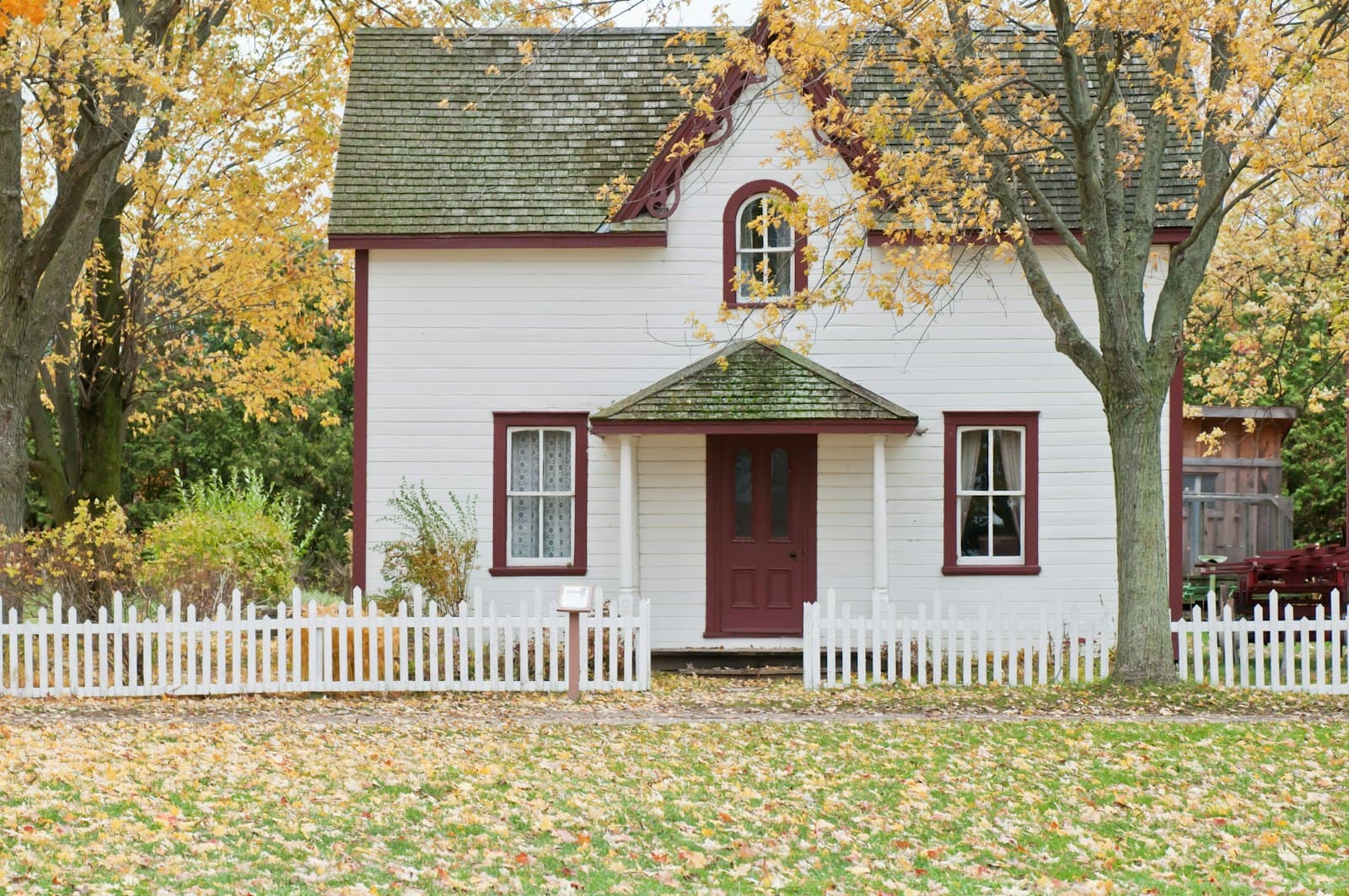 White house beneath maple trees in fall color