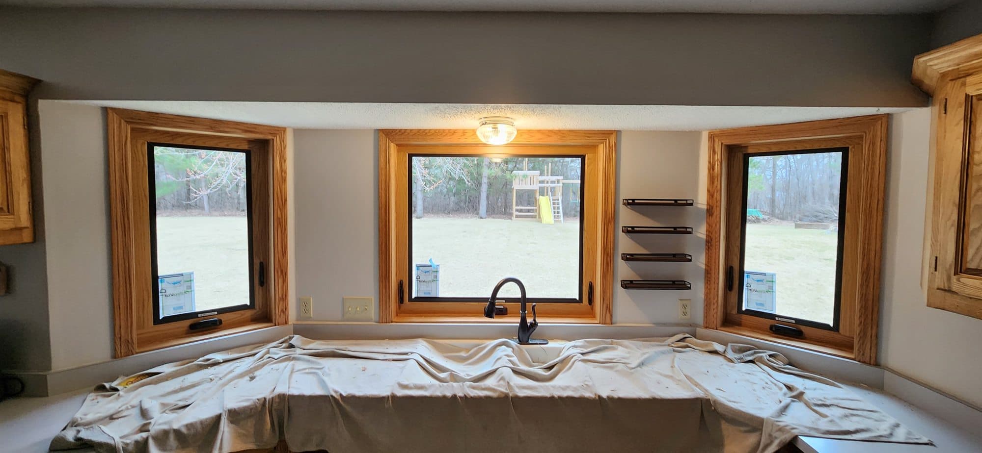 New black casement windows with warm oak trim in a Minnesota kitchen