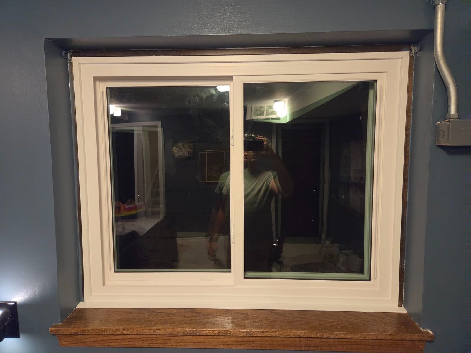 Basement slider window with new natural wood casing and stool