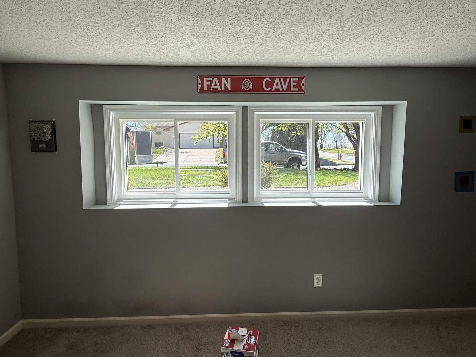 Pair of white-trimmed slider windows in a finished gray basement room
