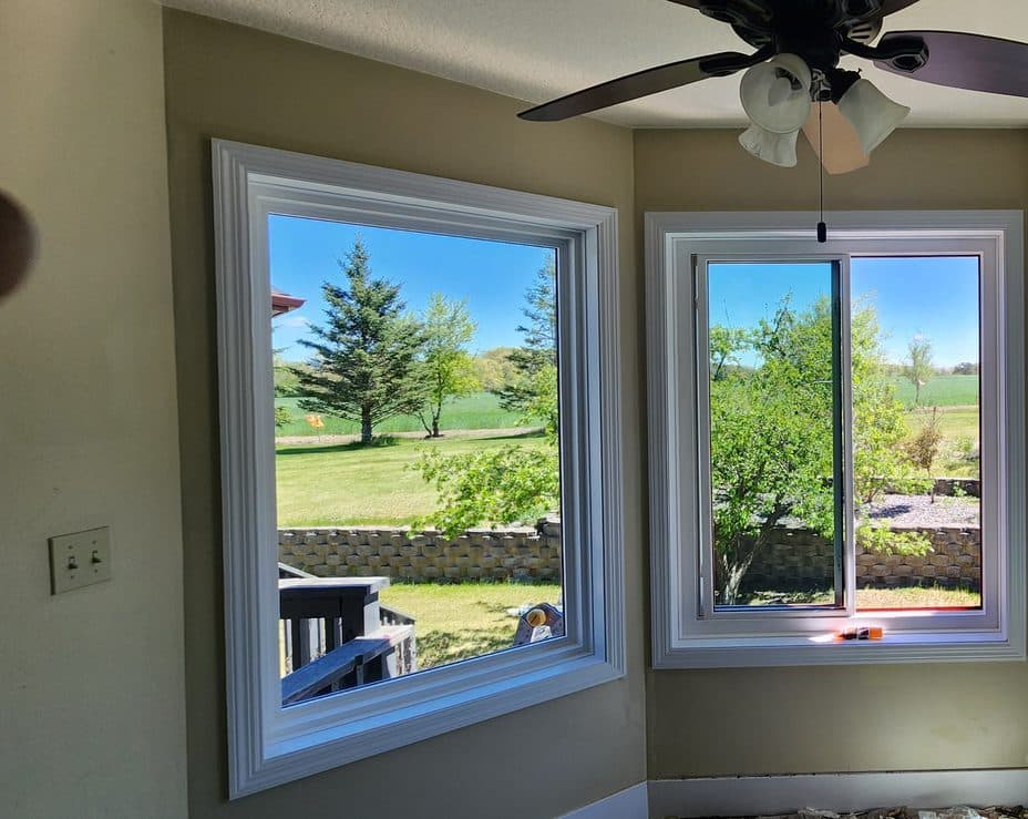 Three-window bay with white casing and a bright country view