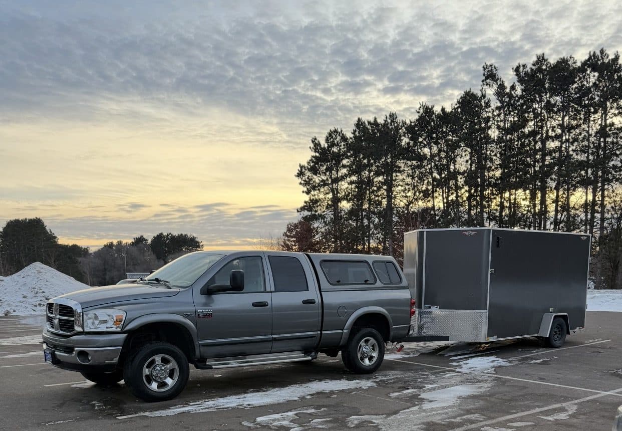 JMB Builders pickup and enclosed job trailer at sunset, loaded for the next window and door install