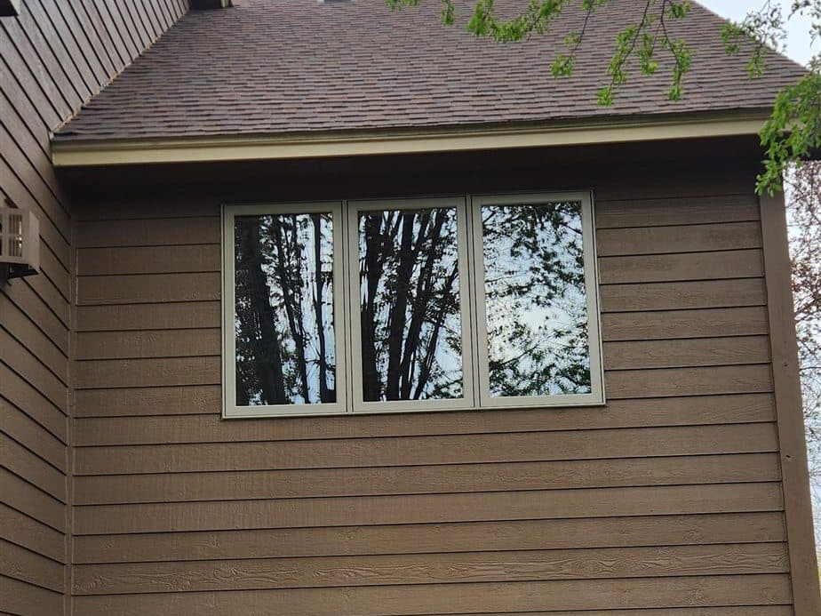 Replacement window with new white exterior trim on a lap-sided Twin Cities home