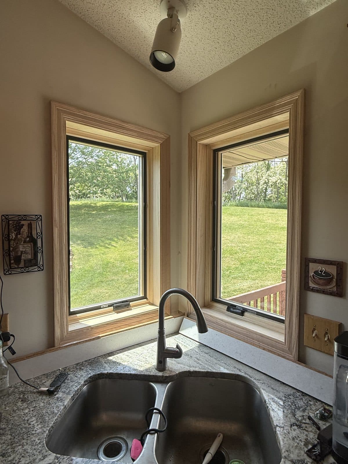 Two new casement windows with fresh pine trim at a corner kitchen sink