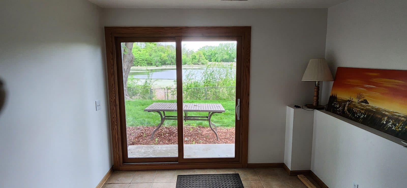 Oak-trimmed sliding patio door with a lake view from the dining room