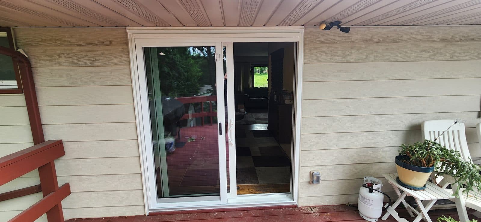 Sliding patio door under a covered porch with deck furniture