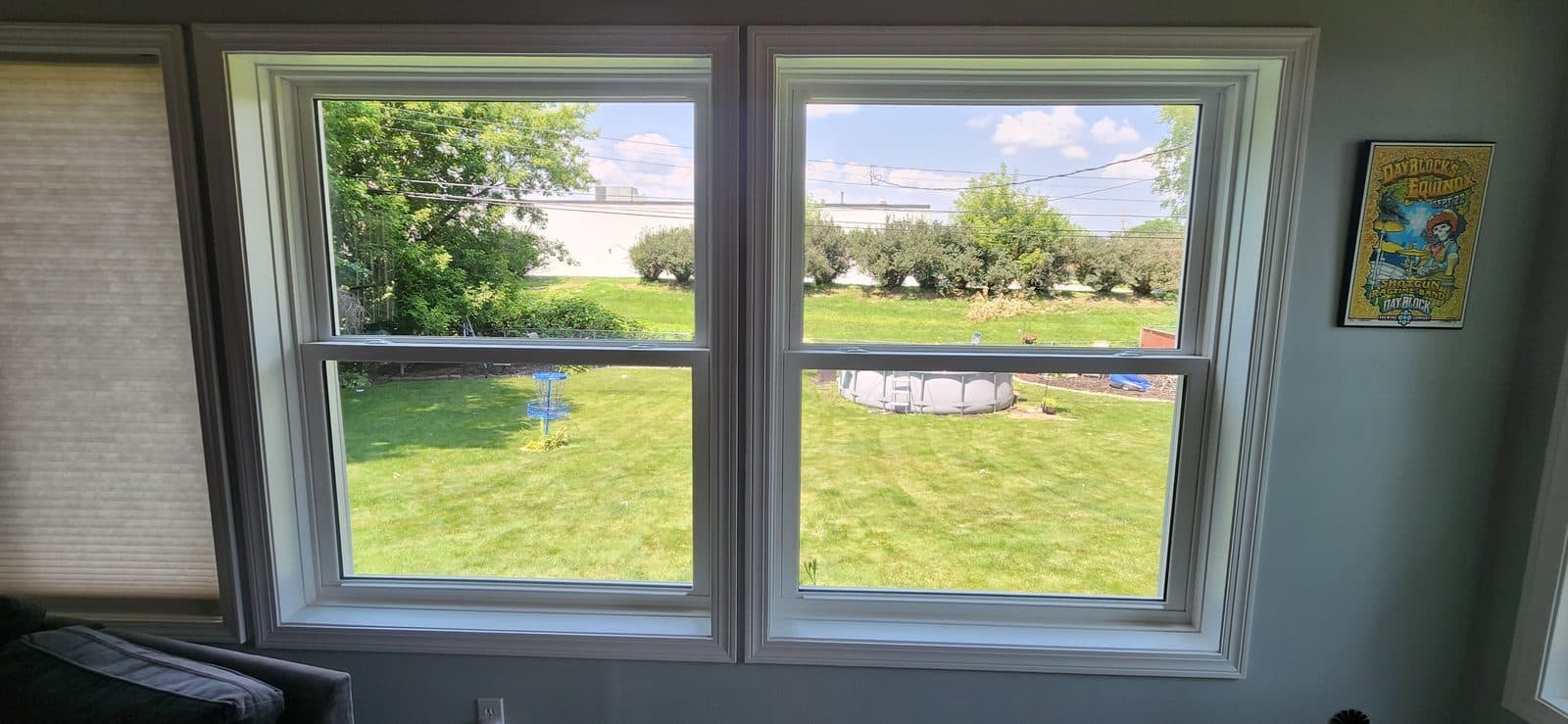 Twin double-hung windows with white trim looking out over a lawn